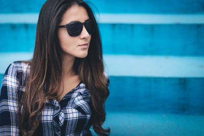 Close-up of young woman wearing sunglasses on steps