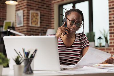 Young businesswoman using laptop at office