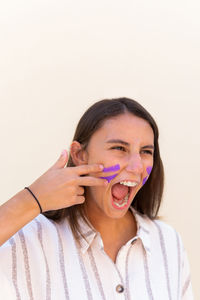 Portrait of young woman with hands against white background