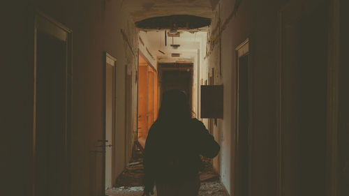 Rear view of woman standing in corridor