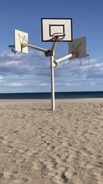 Basketball court on beach against sky