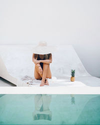 Woman sitting in swimming pool