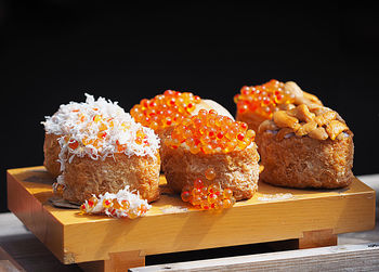 Close-up of cake on cutting board against black background