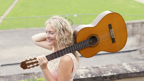 Full length of woman playing guitar