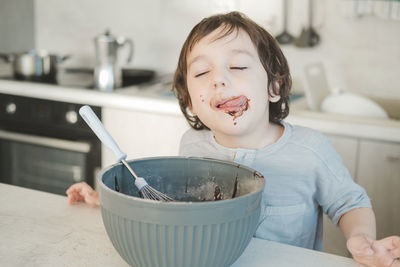 The little boy was smeared with chocolate mixture.