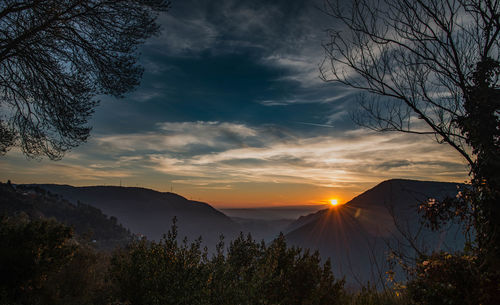 Scenic view of silhouette mountains against sky at sunset