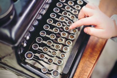 Cropped hand of person using typewriter