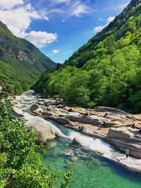 Scenic view of river by mountains against sky