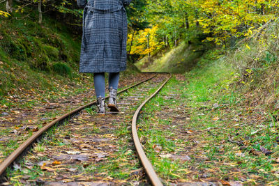 Low section of person walking on railroad track