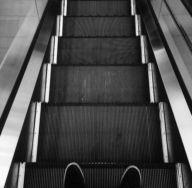 LOW SECTION OF PEOPLE STANDING ON ESCALATOR