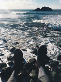 Low section of man relaxing on calm beach