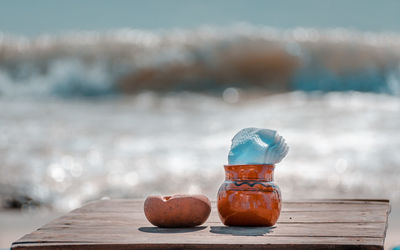 Close-up of fruits on table by sea