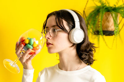 A teenage girl holds a wine glass with easter eggs.