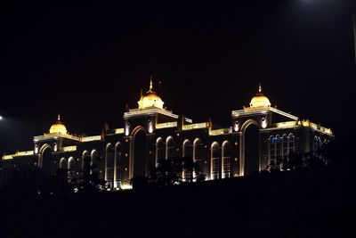 Illuminated building against sky at night