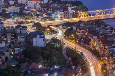 High angle view of illuminated street amidst buildings in city