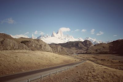 Road leading towards mountains against sky