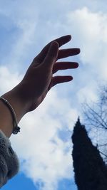 Low angle view of hand against sky