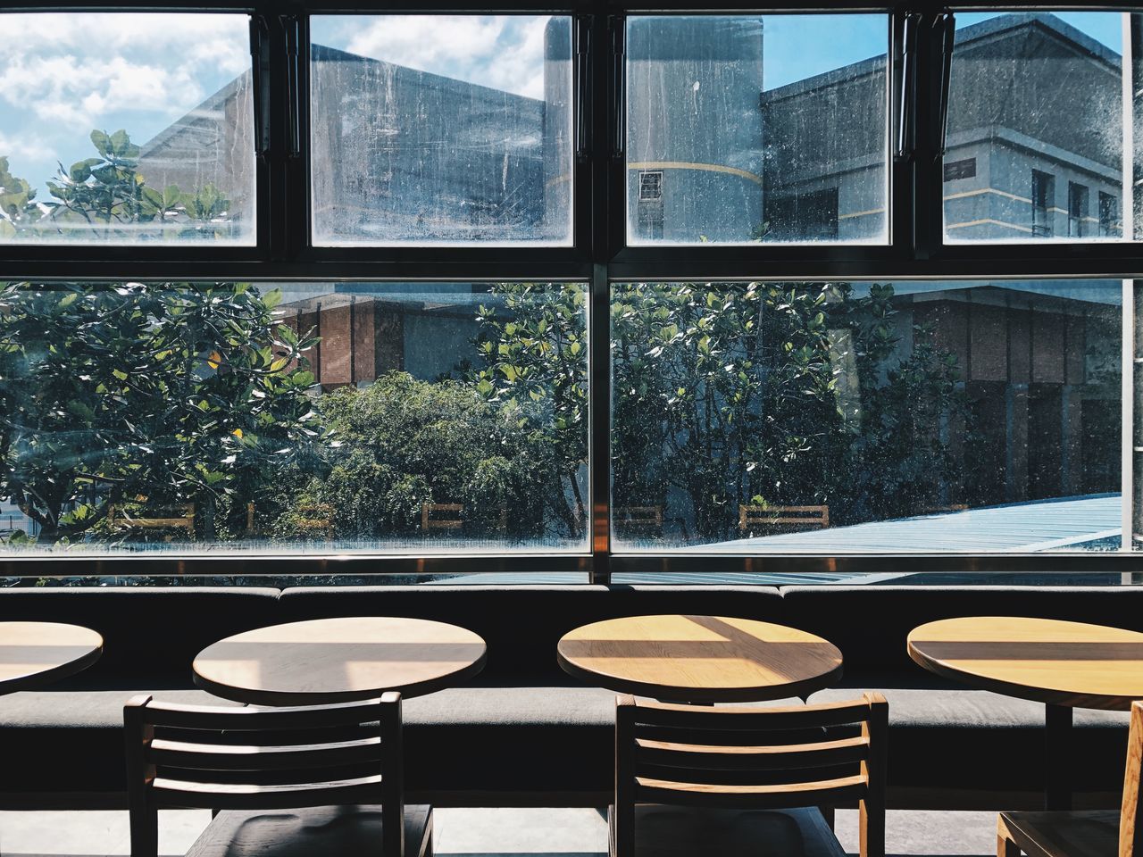 window, room, interior design, table, architecture, seat, no people, glass, indoors, chair, building, built structure, nature, day, home, furniture, empty, plant, window covering, tree, transparent, absence, city, coffee table, dining room, business, home interior