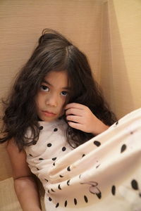 High angle portrait of girl sitting in corner