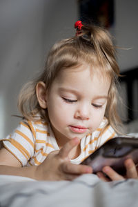 Portrait of cute girl sitting on sofa at home