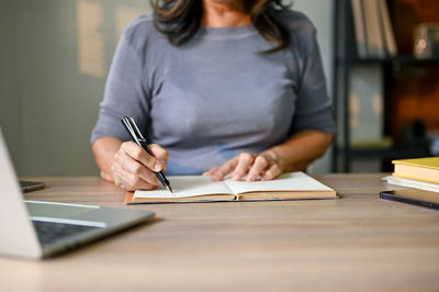 Midsection of woman working at table