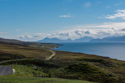 Scenic view of sea and mountains against sky