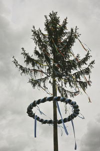 Low angle view of bare tree against cloudy sky