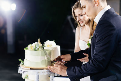 Midsection of couple holding bouquet