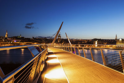 Illuminated bridge against sky at night