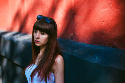 Close-up of thoughtful woman standing by wall