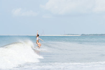 Young woman surfboarding in sea