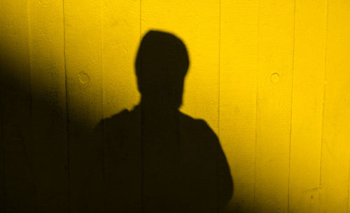 Shadow of person on yellow wall