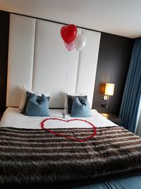 Red balloons on bed at home