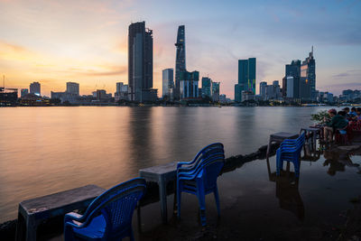 Panoramic view of river and buildings against sky during sunset