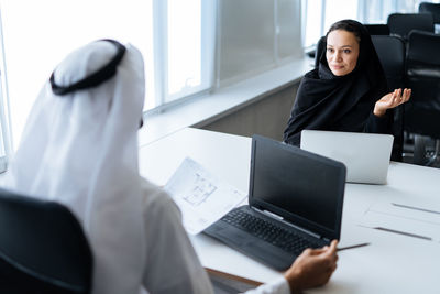 Midsection of woman using laptop at office