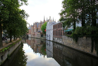 Canal amidst buildings against sky in city