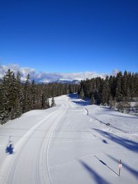 Snow covered land against blue sky