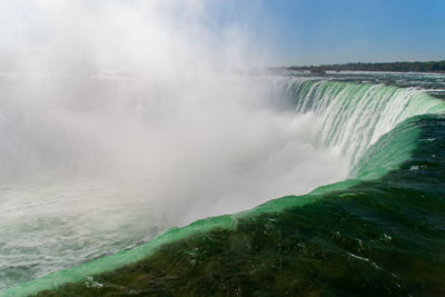 Scenic view of waterfall against sky