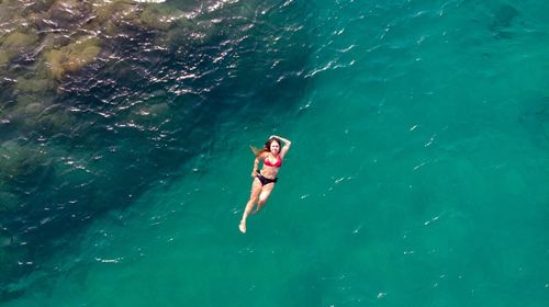 High angle view of bikini woman swimming in sea