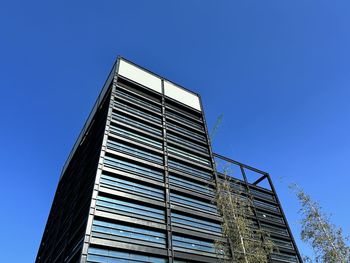 Low angle view of skyscraper against clear blue sky