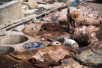 High angle view of workers tanning leather in pits