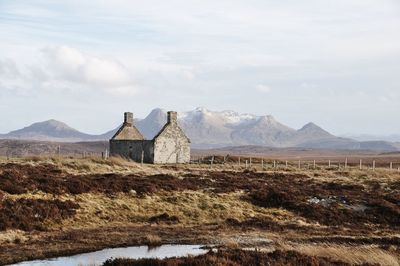 Built structure on landscape against sky