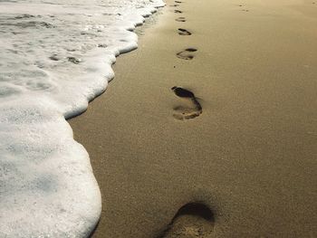 High angle view of footprints on sand at beach