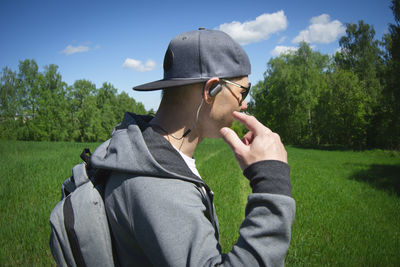 Man holding umbrella on field against sky