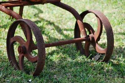 Close-up of rusty machine part on field