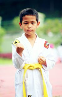 Portrait of boy practicing karate outdoors