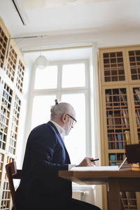 Low angle view of senior lawyer researching in library