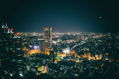 Illuminated cityscape against sky at night