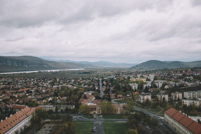 Aerial view of townscape against cloudy sky