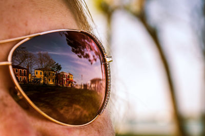 Reflection of person on sunglasses against sky